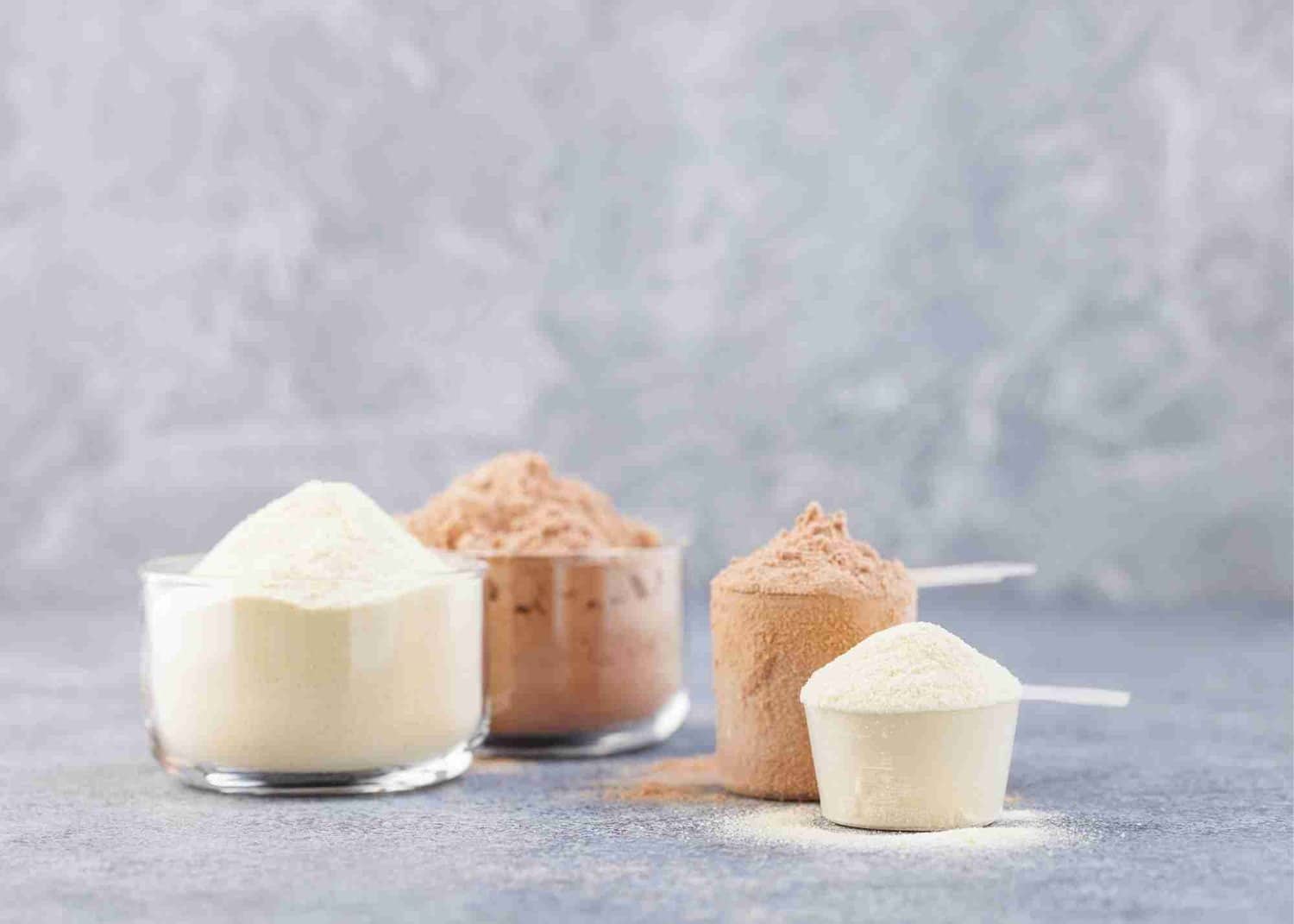 Scoops of various protein powders on a table