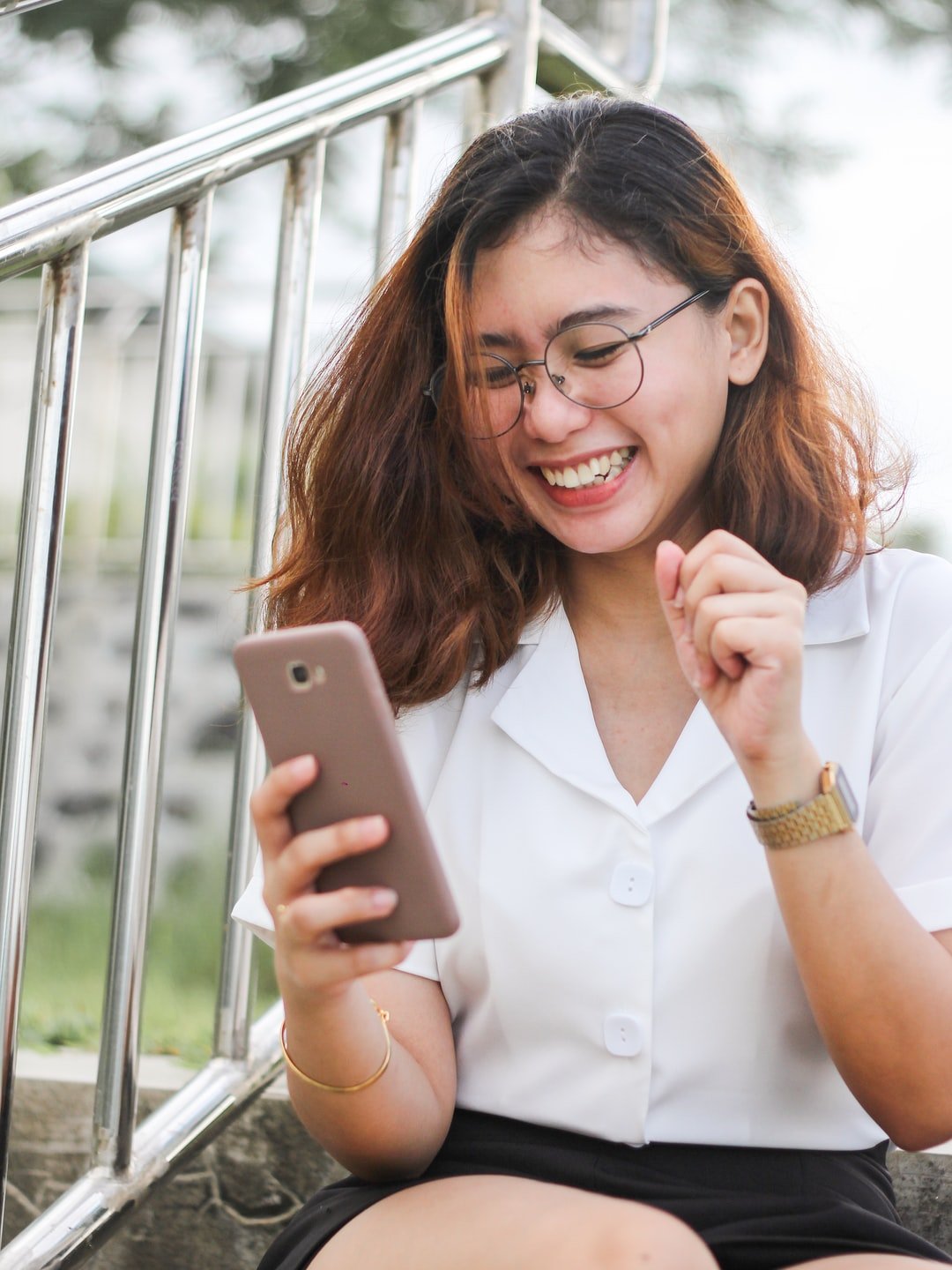 Young woman looking excitedly at her smartphone