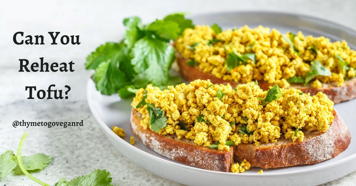 Photo of tofu scramble toast on a white plate with text overlay reading "can you reheat tofu?"
