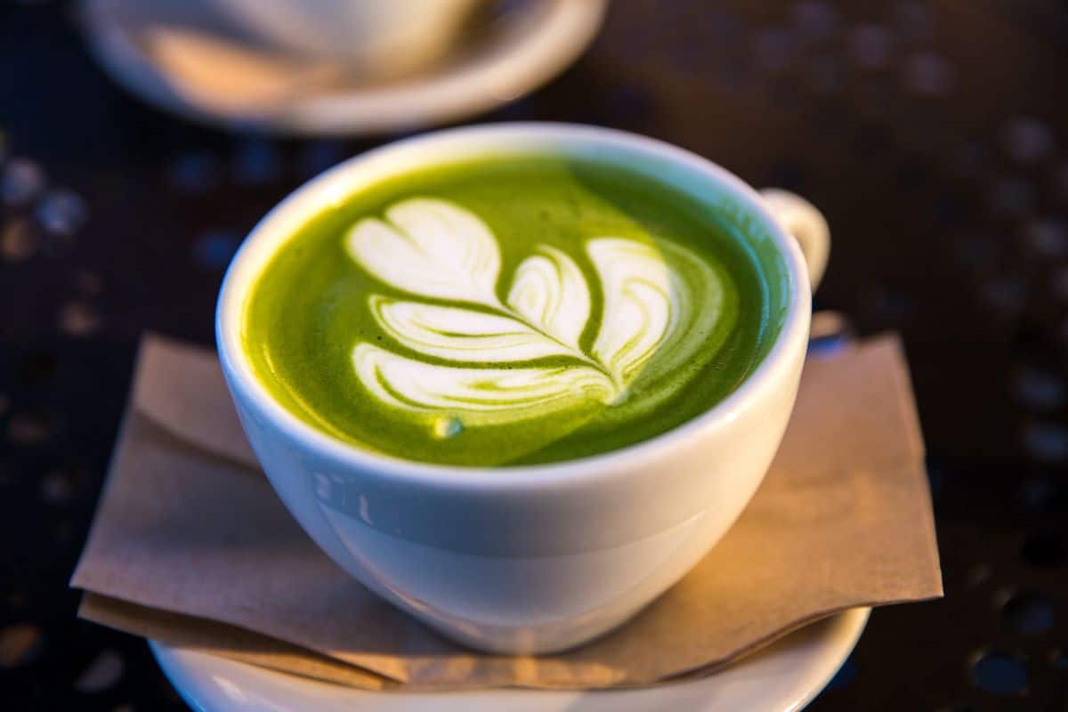 Matcha latte in a white mug on a napkin and saucer