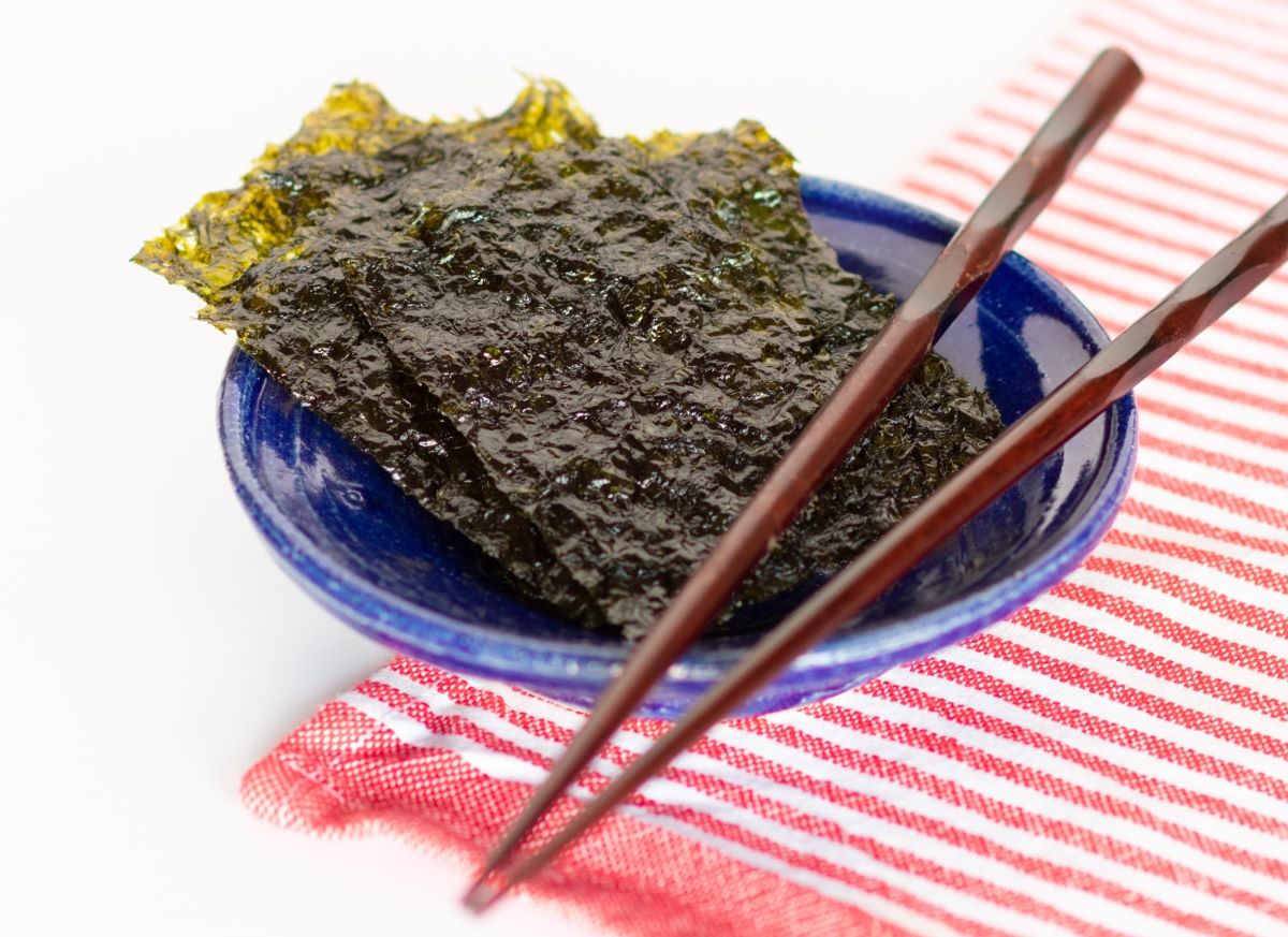 Sheets of nori in a bowl with chopsticks
