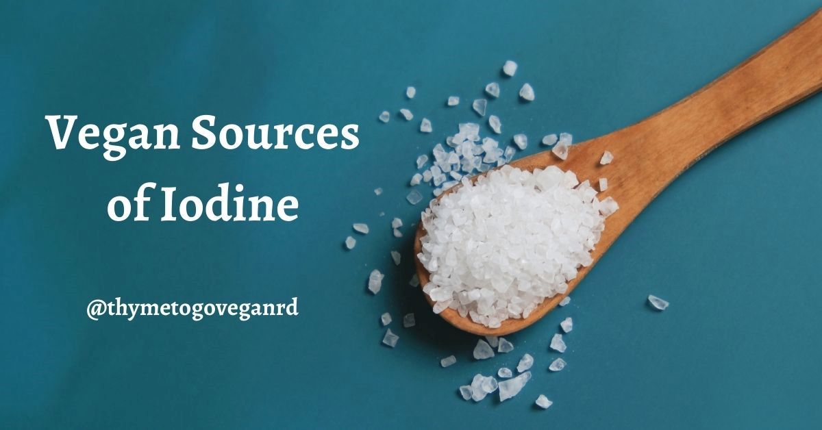 A wooden spoon with iodized salt on a blue background with text overlay reading "vegan sources of iodine"